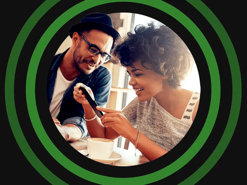 Two Unibet players checking an account on a phone